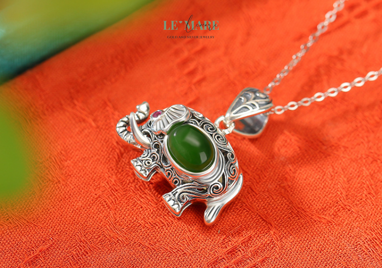 Dây Chuyền Ngọc Bích Ngọc Tượng – Dáng ngọc của trí tuệ và phúc lành BNDC08 Trong dây chuyền nữ "Ngọc Tượng", hình dáng con voi được khắc họa mềm mại, tinh tế trong từng đường cong, với đôi tai xòe rộng như cánh sen và ánh mắt hiền từ – biểu trưng cho trái tim bao dung và trí tuệ sâu thẳm. Đây không chỉ là một món dây chuyền ngọc bích, mà còn là lá bùa hộ mệnh tinh tế, mang đến cảm giác an yên, tự tin cho người đeo.