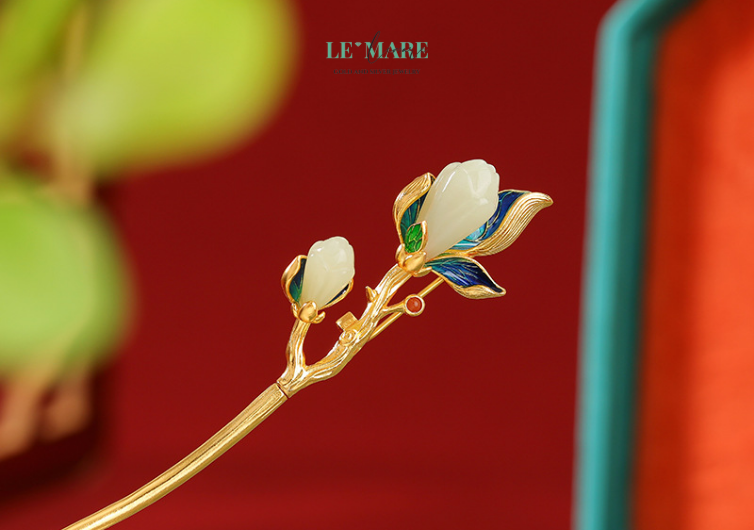 Trâm cài tóc ngọc bích Khai Hoa – Vẻ Đẹp Thanh Tân Nở Rộ Từ Một Cành Trâm BNTC05 Chiếc trâm cài tóc ngọc bích nữ này không phô trương lộng lẫy, mà chọn cách lặng lẽ tỏa hương – như chính những người phụ nữ sâu sắc và tinh tế. Mỗi chi tiết của cành hoa nở đều được chạm khắc tỉ mỉ, ôm lấy từng đường cong của chiếc trâm bạc, tỏa ra một thứ ánh sáng mềm dịu, như ánh nắng đầu ngày chạm vào cánh hoa sớm mai.