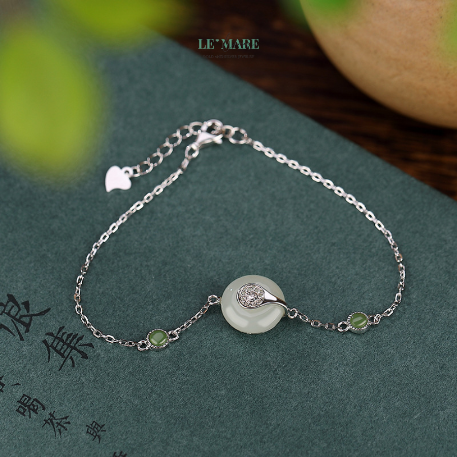 Viên Tĩnh – Khi vẻ đẹp tỏa ra từ sự tĩnh tại BNVT99 Chiếc vòng tay ngọc bích nữ "Viên Tĩnh" được chế tác từ bạc nguyên chất, uốn thành dáng lắc nhẹ nhàng ôm cổ tay, làm nổi bật viên ngọc bích trung tâm như một vầng trăng tròn giữa bầu trời đêm. Từng chi tiết nhỏ đều được chăm chút để không có gì thừa, không có gì gượng ép – để viên ngọc được “thở”, để vẻ đẹp được tự nhiên lan tỏa.